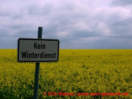 Schild "Kein Winterdienst" vor Rapsfeld